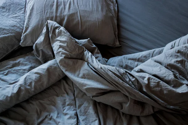 Blaue Bettwäsche und Kissen nach dem Schlafen. — Stockfoto