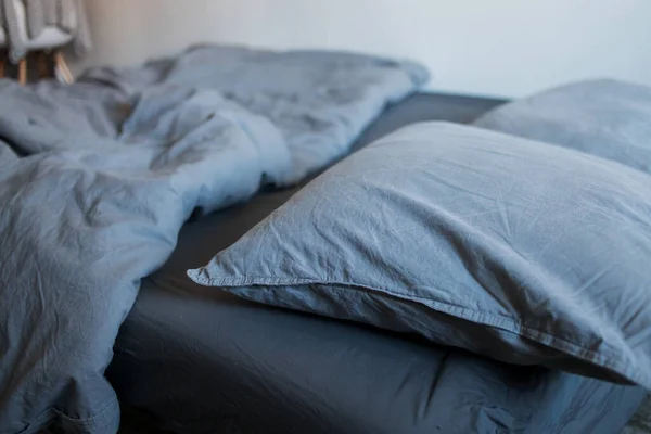 Blue bed sheets and pillows after nights sleep. — Stock Photo, Image