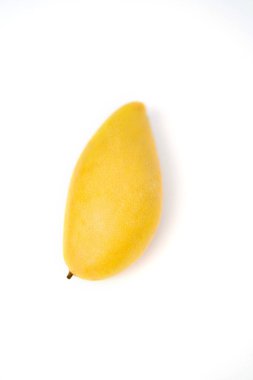 Bir mango meyvesi. Lezzetli olgun sulu taze sarı mango beyaz arka planda izole edilmiş. Egzotik tropikal meyveler.
