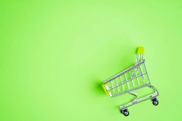 空金属购物车隔离在粉色绿色背景与复制空间为您的文字或设计 超级市场 购物中心 销售概念 — 图库照片