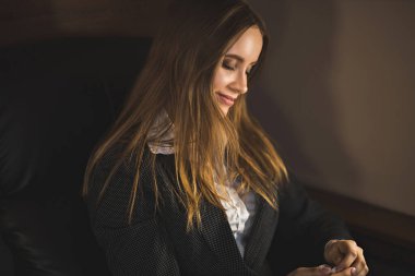 Yakından çekilen, beyaz bluz ve takım elbiseli, uçarken rüya gören, dinlenen güzel kahverengi saçlı genç bayan fotoğrafı. Birinci sınıf uçuyor..