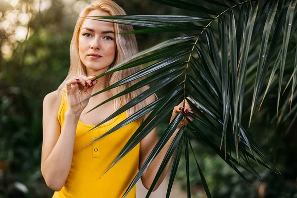美丽的女孩 有着天然的妆容和金发 站在热带雨林的异国情调的树木中 热带植物中穿着黄色泳衣的漂亮女人的画像 — 图库照片