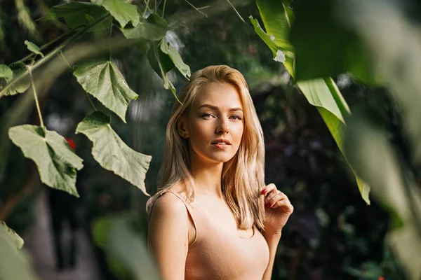 森林中美丽的年轻女子的画像 可爱的高加索女孩 有着天然的妆容和金发 站在异国情调的植物中间 遥望远方 夏天的概念 — 图库照片
