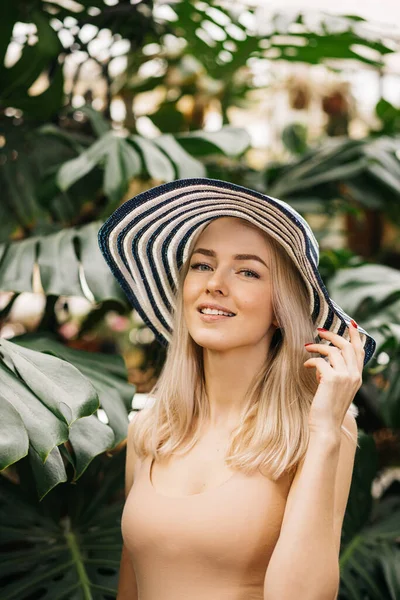 一个有着金发碧眼 头戴帽子 闭眼微笑 享受阳光 在热带度假胜地放松的快乐迷人的高加索年轻女子的垂直特写 夏季概念 — 图库照片
