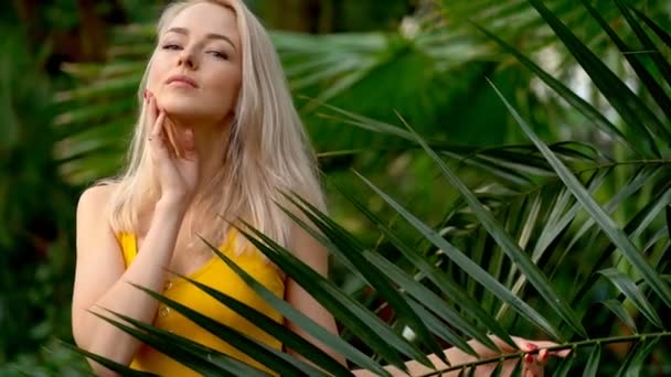Žena v plavkách na pozadí tropických rostlin — Stock video