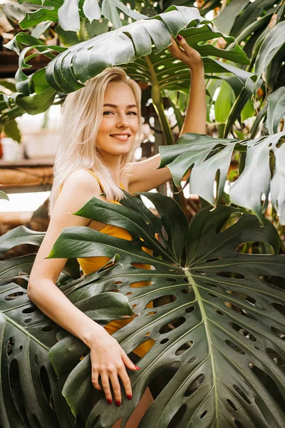 Mujer en traje de baño sobre fondo de plantas tropicales —  Fotos de Stock
