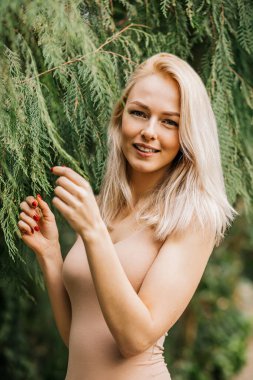 Tropik bitki arka planında mayo giymiş bir kadın.