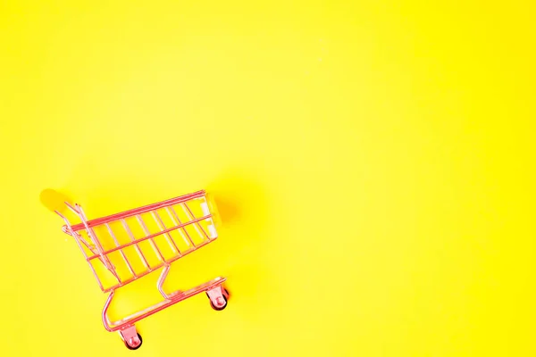 Nákupní vozík na barevném pozadí — Stock fotografie