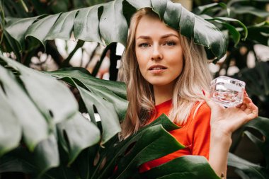 Güzel kadın elinde güzellik ürünü tutuyor.