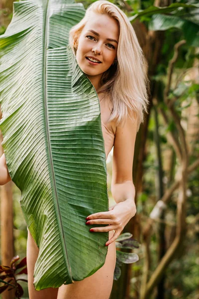 Donna in costume da bagno su sfondo piante tropicali — Foto Stock