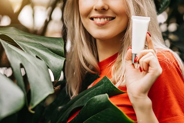 Hermosa mujer sosteniendo producto de belleza — Foto de Stock