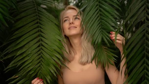 Женщина в купальнике на фоне тропических растений — стоковое видео