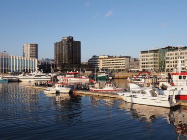 BODO, NORWAY on JULY 2019: Panoramic view to port with yachts and modern hotels in european city at Salten region with clear blue sky in warm sunny summer day at sun set.