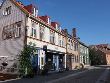 TRONDHEIM, NORWay, Temmuz 2019: Avrupa 'nın Nidaros şehrinde güneşli yaz gününde açık mavi gökyüzü olan güzel ahşap evleri olan sessiz dar bir cadde..