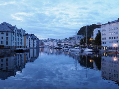 TELEFON, NORWay, Temmuz 2019: Avrupa 'nın muhteşem evleri Romsdal bölgesindeki suya yansıdı sıcak yaz gününde akşam saatlerinde, mavi saatte bulutlu gökyüzü.