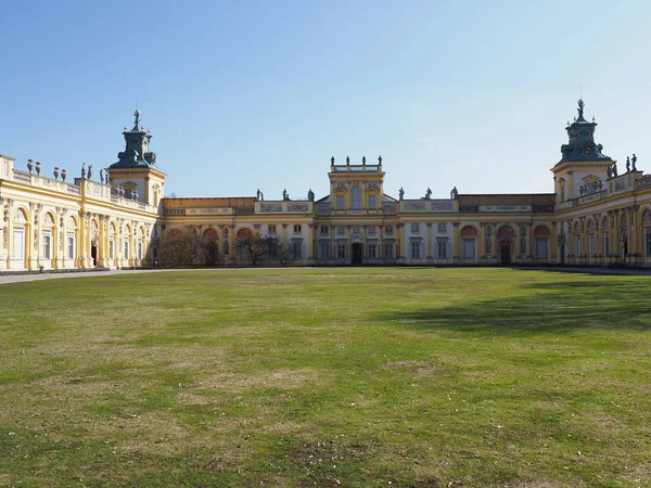 Lawn at main courtyard and facade of palace in european Warsaw capital city of Poland, clear blue sky in 2019 warm sunny spring day on March.