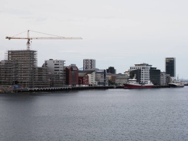 BODO, NORway, Temmuz 2019: Avrupa 'nın Salten bölgesindeki gemiler ve modern binalar ve soğuk yaz sabahlarında bulutlu gökyüzü.