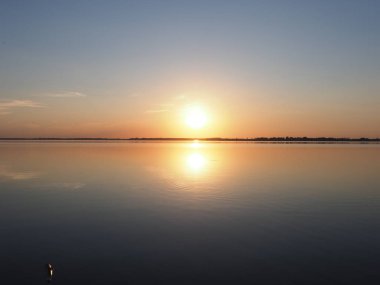 Polonya 'nın Pszczyna kenti yakınlarındaki Goczalkowice Reservoir ve kıyı şeridi üzerinde güneşli bir güneş manzarası, 2018 yılında açık mavi gökyüzü Temmuz ayında güneşli bir yaz akşamı.