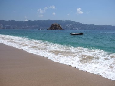 Meksika 'daki Acapulco şehrinde beyaz dalgalı ve tekneli sahil.