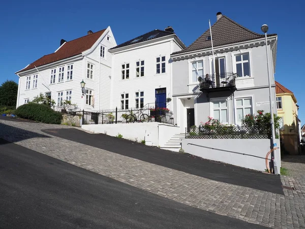 Three traditional houses in city center of european Bergen town at Hordaland region in Norway, clear blue sky in 2019 warm summer day on July.