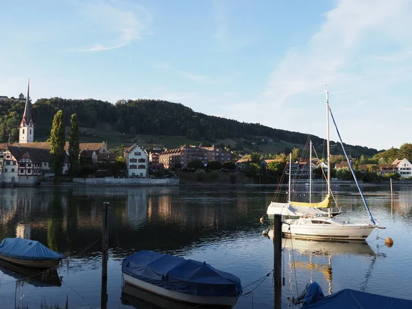STEIN am RHEIN, SWITZERLAND on AUGUST 2018: Boats and St. George's Abbey at Rhine River at european town, canton Schaffhausen, clear blue sky at evening.