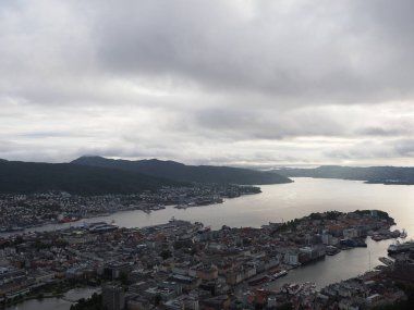 BERGEN, NORWay, Temmuz 2019: Avrupa Bergen şehri manzarası ve Hordaland ilçesinde fiyort soğuk yaz gününde bulutlu gökyüzü.