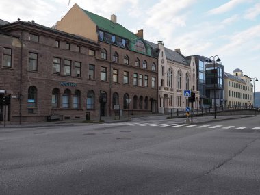 ALESUND, NORWay, Temmuz 2019: Avrupa 'nın Romsdal bölgesindeki tarihi binalar, sıcak yaz akşamında bulutlu gökyüzü.