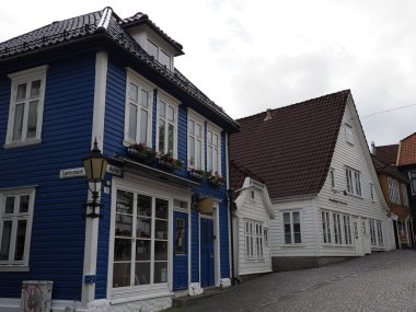 BERGEN, NORWAY on JULY 2019: Two traditional houses in city center of european town at Hordaland region, cloudy sky in warm summer day.