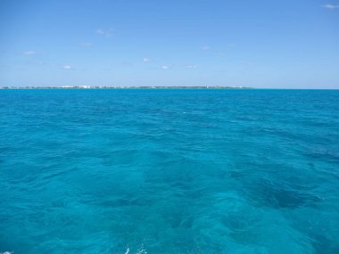Meksika 'nın Quintana Roo eyaletindeki Isla Mujeres ve Cancun şehri arasındaki parlak su, 2018' in güneşli kış gününde açık mavi gökyüzü, Mart ayında Kuzey Amerika.