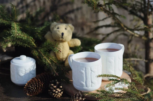 Twee kopjes thee met kerstversiering op een rustieke houten achtergrond — Stockfoto