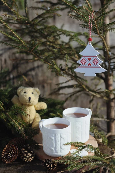 Twee kopjes thee met kerstversiering op een rustieke houten achtergrond — Stockfoto