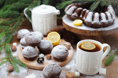 Çikolata cupcakes ve ve Noel tatil arka plan üzerinde limonlu çay fincan