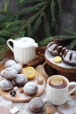 Çikolata cupcakes ve ve Noel tatil arka plan üzerinde limonlu çay fincan