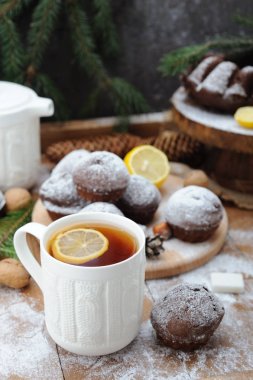 Çikolata cupcakes ve ve Noel tatil arka plan üzerinde limonlu çay fincan