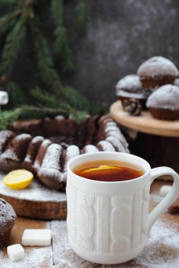 Çikolata cupcakes ve ve Noel tatil arka plan üzerinde limonlu çay fincan