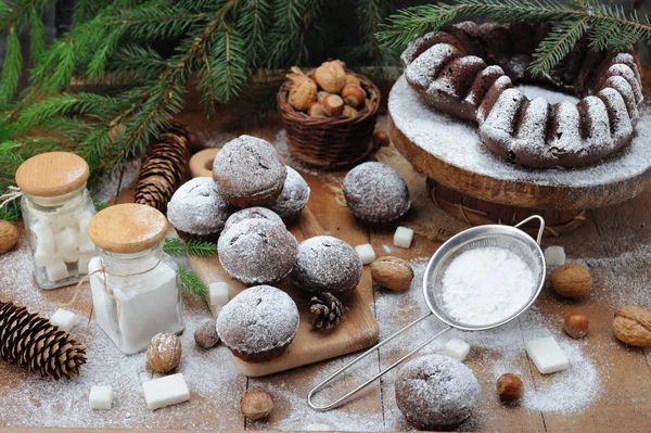 Chocolate muffin and cupcakes with holiday decorations on a rustic wood background — Stock Photo, Image