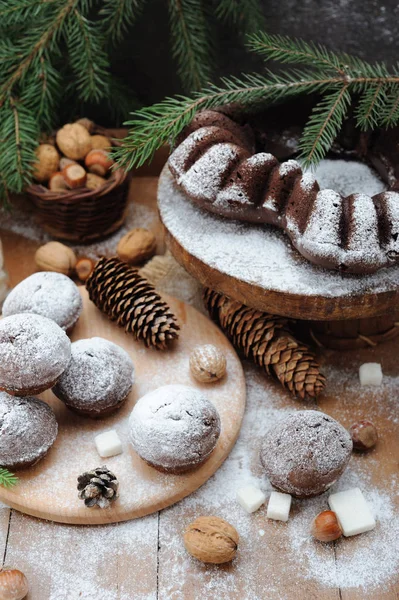 Chocolate muffin and cupcakes with holiday decorations on a rustic wood background — Stock Photo, Image