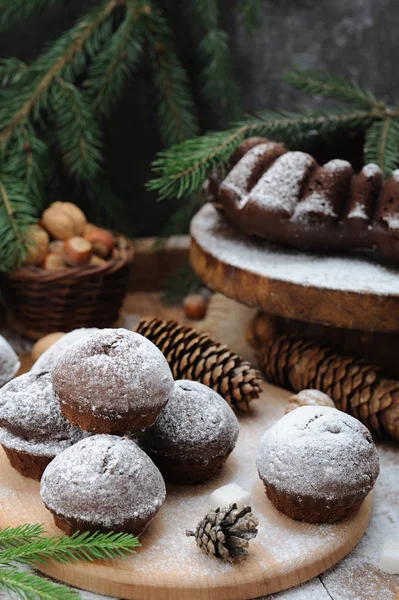 Cupcakes de chocolate com açúcar em pó na mesa de decorações de Natal — Fotografia de Stock