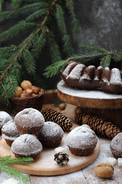 Chocolate cupcakes with sugar powder on Christmas decorations table — Stock Photo, Image