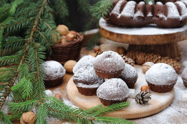 Cupcakes de chocolate com açúcar em pó na mesa de decorações de Natal — Fotografia de Stock