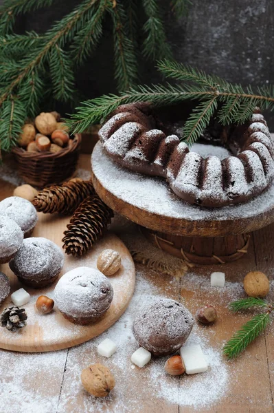 Cupcakes de chocolate com açúcar em pó na mesa de decorações de Natal — Fotografia de Stock