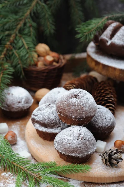 Bolo de chocolate e cupcakes com decorações de férias em um fundo de madeira rústica — Fotografia de Stock