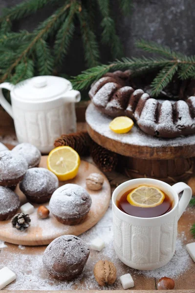 Chocolate cupcakes and and cup of tea with lemon on Christmas holiday background — Stock Photo, Image