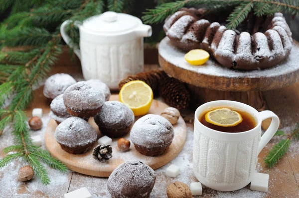 Çikolata cupcakes ve ve Noel tatil arka plan üzerinde limonlu çay fincan
