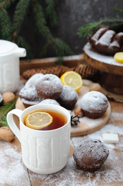 Cupcakes de chocolate e e xícara de chá com limão no fundo de férias de Natal — Fotografia de Stock