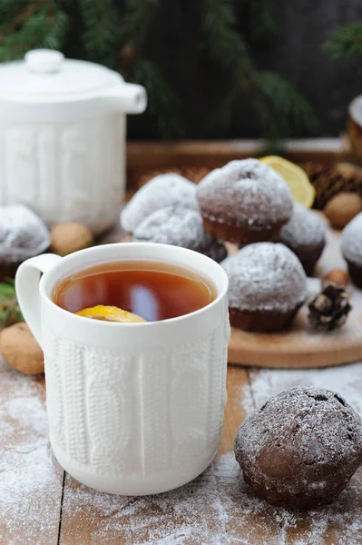 Çikolata cupcakes ve ve Noel tatil arka plan üzerinde limonlu çay fincan