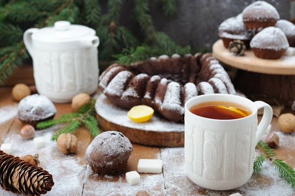 Cupcakes de chocolate e e xícara de chá com limão no fundo de férias de Natal — Fotografia de Stock