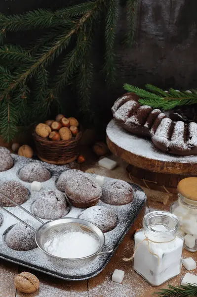 Magdalena de chocolate y cupcakes con decoraciones navideñas sobre un fondo rústico de madera — Foto de Stock