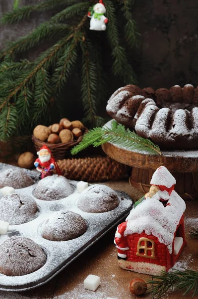 Bolo de chocolate e cupcakes com decorações de férias em um fundo de madeira rústica — Fotografia de Stock