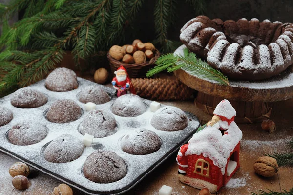 Κέικ σοκολάτας και cupcakes με διακοσμήσεις διακοπών σε ρουστίκ ξύλινα φόντο — Φωτογραφία Αρχείου